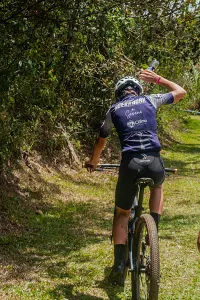 Guy pouring water on head in mtb